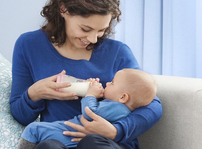 Mutter füttert Baby mit Anti Colic 
